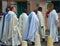 Preachers in church robes walk down the street during a festive procession