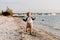 Precious Adorably Cute Happy Baby Boy Toddler Smiling and Playing in the Sand At the Beach Next to the Ocean Water Outside During