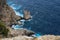 On a precipice. View from the cliff on the waves breaking on the shore. Cape Formentor. Majorca. Spain