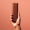 Precise Hyperrealism: Handheld Milk Chocolate Bar Against Pink Background