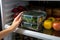 Precise moment Female hands grasp food container from fridge, close up perspective