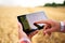 Precision farming. Farmer hands hold tablet using online data management software with maps at wheat field. Agronomist