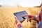 Precision farming. Farmer hands hold tablet using online data management software with maps at wheat field. Agronomist