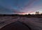 Predawn light paints the sky above rain filled pools on Gooseberry Mesa in Southern Utah