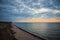 Predawn sky at the sea on a cloudy morning. Ships can be seen against the background of sunrise on the horizon. Dropping off the