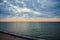 Predawn sky at the sea on a cloudy morning. Ships can be seen against the background of sunrise on the horizon. Dropping off the