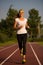 Preety young woman running on a track