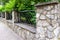 Prefab metal fence on concrete foundation pile of stones loose stone construction of houses and yards construction works