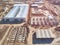 Prefabricated frame industrial buildings and building materials warehouse at construction site top down aerial view