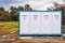 Prefabricated portable cabin with four doors with numbers on them on a meadow field i