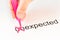 The prefix `un` of the word unexpected is crossed out with a pink pencil by a hand