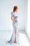 Pregnancy beauty. Beautiful elegant readhead pregnant woman in white dress posing in tender home interior.