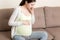 Pregnancy Morning Sickness. Pregnant Woman Having Nausea Feeling Bad in Sofa at the Home