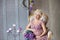 Pregnancy, motherhood and happy future mother concept - pregnant woman in airy violet dress with bouquet flowers against colorful