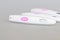 Pregnancy test close-up with a big pink button on a gray background