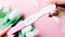 Pregnancy test couple. Positive woman pregnant test in hands with pink silk ribbon on tulips flower pink background. New