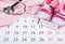 Pregnancy test with positive result, clothing for newborn and stethoscope on calendar, expecting for baby