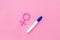 Pregnancy test with two strips and Venus sign - baby girl expectation - on pink background top-down