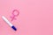 Pregnancy test with two strips and Venus sign - baby girl expectation - on pink background top-down copy space