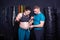 Pregnancy theme in a sports family. Caucasian couple of athletes having fun in the gym after training while measuring the