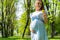 Pregnancy woman walk. Pregnant nature walk. Happy maternity mother in summer park. Baby belly. Pregnancy activity.