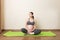 Pregnancy Yoga and Fitness concept at coronavirus time. Pregnant woman meditates indoor in yoga pose. Woman enjoying in meditation