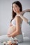Pregnant asian nice woman sitting bed and having relaxing oriental prenatal massage