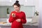 Pregnant beautiful girl holding apple in hand. Attractive future mother feels relaxed and happy, charming woman has good health,