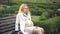 Pregnant blond woman hardly breathing, sitting on bench, feeling abdominal pain