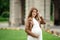 Pregnant brunette woman at an old building gazebo