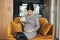 Pregnant businesswoman in elegant dress, sitting on a modern sofa