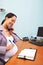 Pregnant businesswoman on the office phone