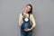 Pregnant cheerful woman holding clock