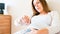 Pregnant contractions time. Pregnancy woman watching clock, holding baby belly. Childbirth time, contractions pain