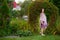 Pregnant country women stands with a toy in the garden