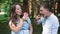 Pregnant couple eating donuts in summer park