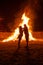 Pregnant couple in front of a giant fire