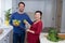 Pregnant couple holding sweet limes and digital tablet in the kitchen