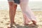 Pregnant couple in love feet on the beach