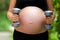 Pregnant female do exercise, side view, body part, lifting dumbbells, active and sportive pregnancy, healthy motherhood concept