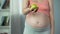 Pregnant female holding out fresh green apple, enjoying healthy diet, vitamins