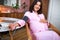 Pregnant female measures blood pressure with automatic sphygmomanometer at home