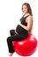 Pregnant fitness woman doing exercise on fitball on white background