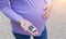 A pregnant girl with a big belly holds a car key in her hand. Known for the dangers of driving a car during pregnancy, the threat