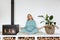 Pregnant girl in green sportswear sits in lotus position doing yoga smiling in cozy interior