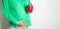 A pregnant girl holds a red pot with a cactus against the background of her belly. The concept of cramping stabbing pain in