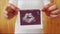 A pregnant girl with a large belly holds out a photo of the unborn child with an ultrasound. The woman holds out a