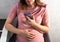 A pregnant girl with a smartphone surfs the Internet. The concept of a negative impact on the unborn child in the womb. Violation