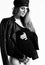 Pregnant girl in sunglasses, black leotard, hat, leather jacket and stockings. She posing sideways isolated on white. Close up