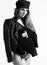 Pregnant girl in sunglasses, black leotard, hat, leather jacket and stockings. She posing sideways isolated on white. Close up
